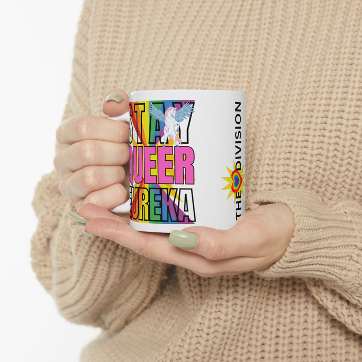 Holding the Stay Queer Eureka mug