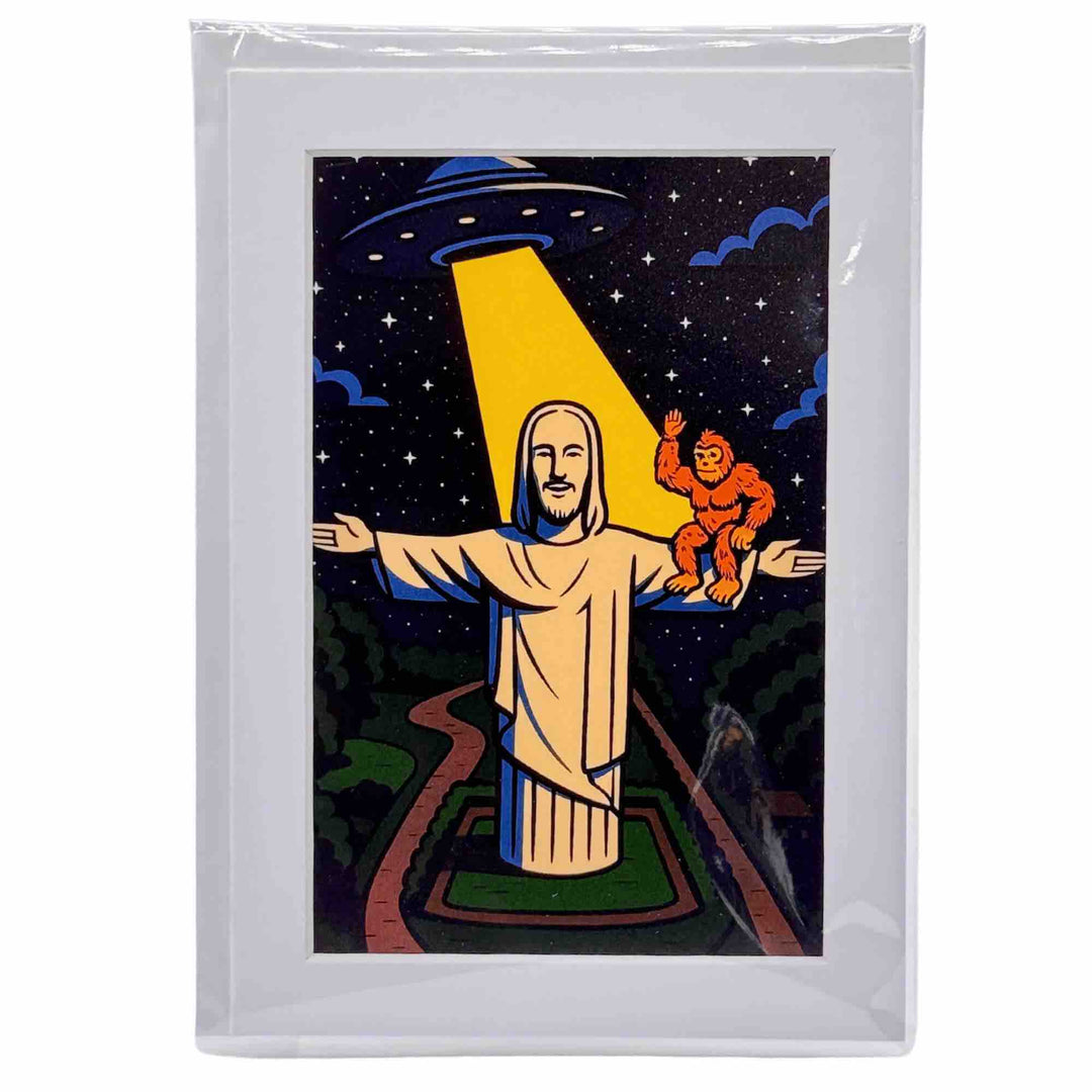 A greeting card with Bigfoot, Christ of the Ozarks Jesus, and a UFO hovering over dark Ozark hills under a starry sky.