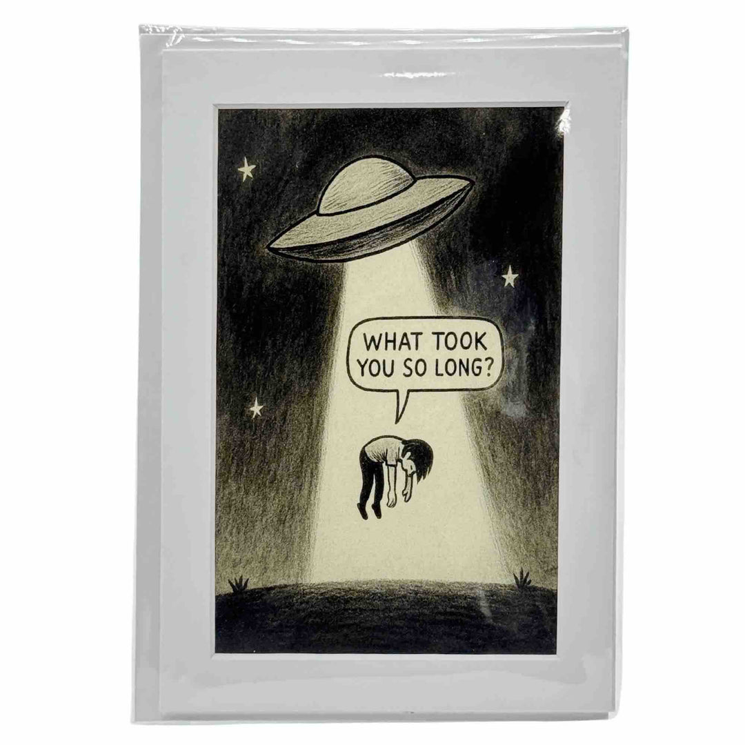 A greeting card with a meme about a human being beamed up into a glowing UFO above in Eureka Springs Arkansas.

