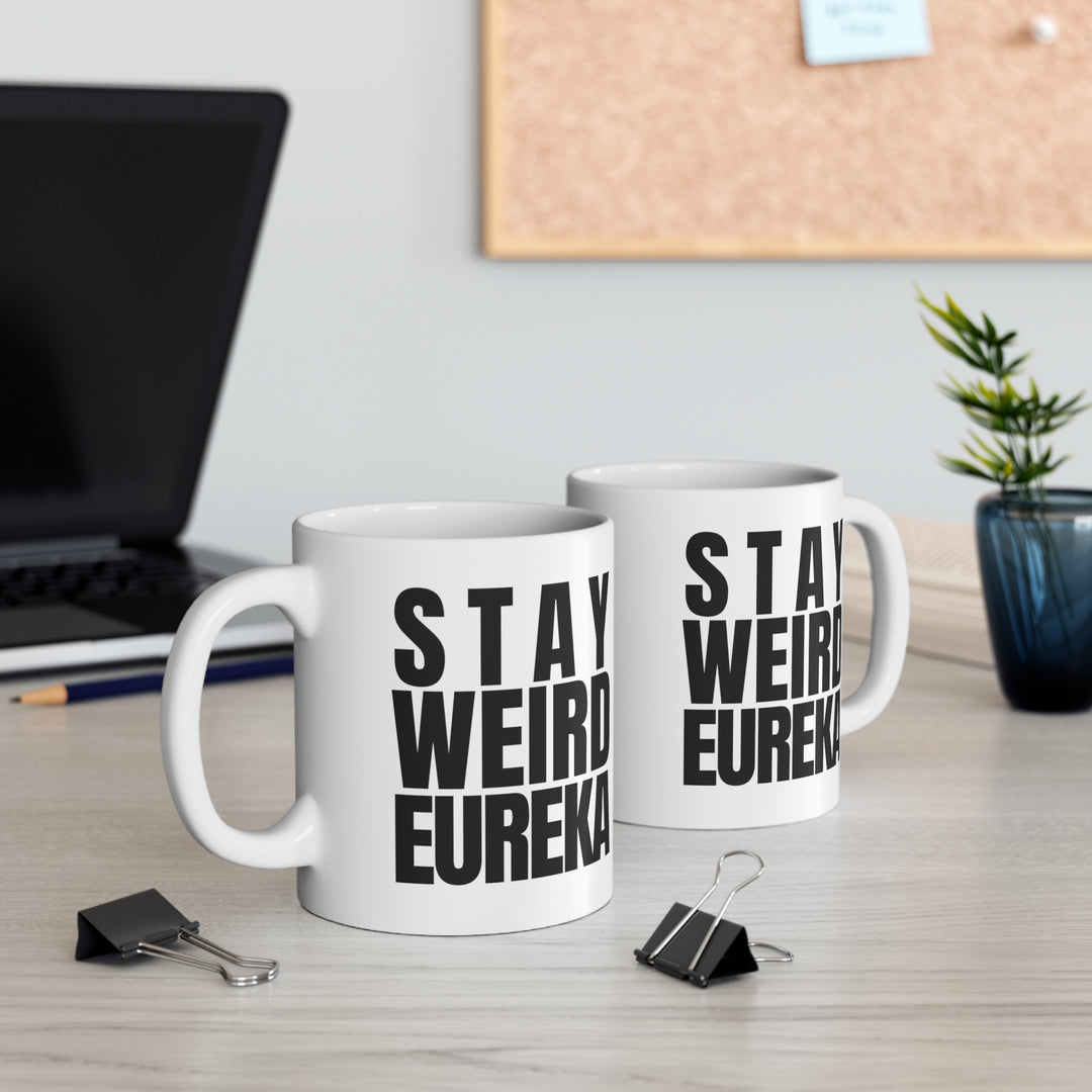 Stay Weird Eureka Mug on a desk