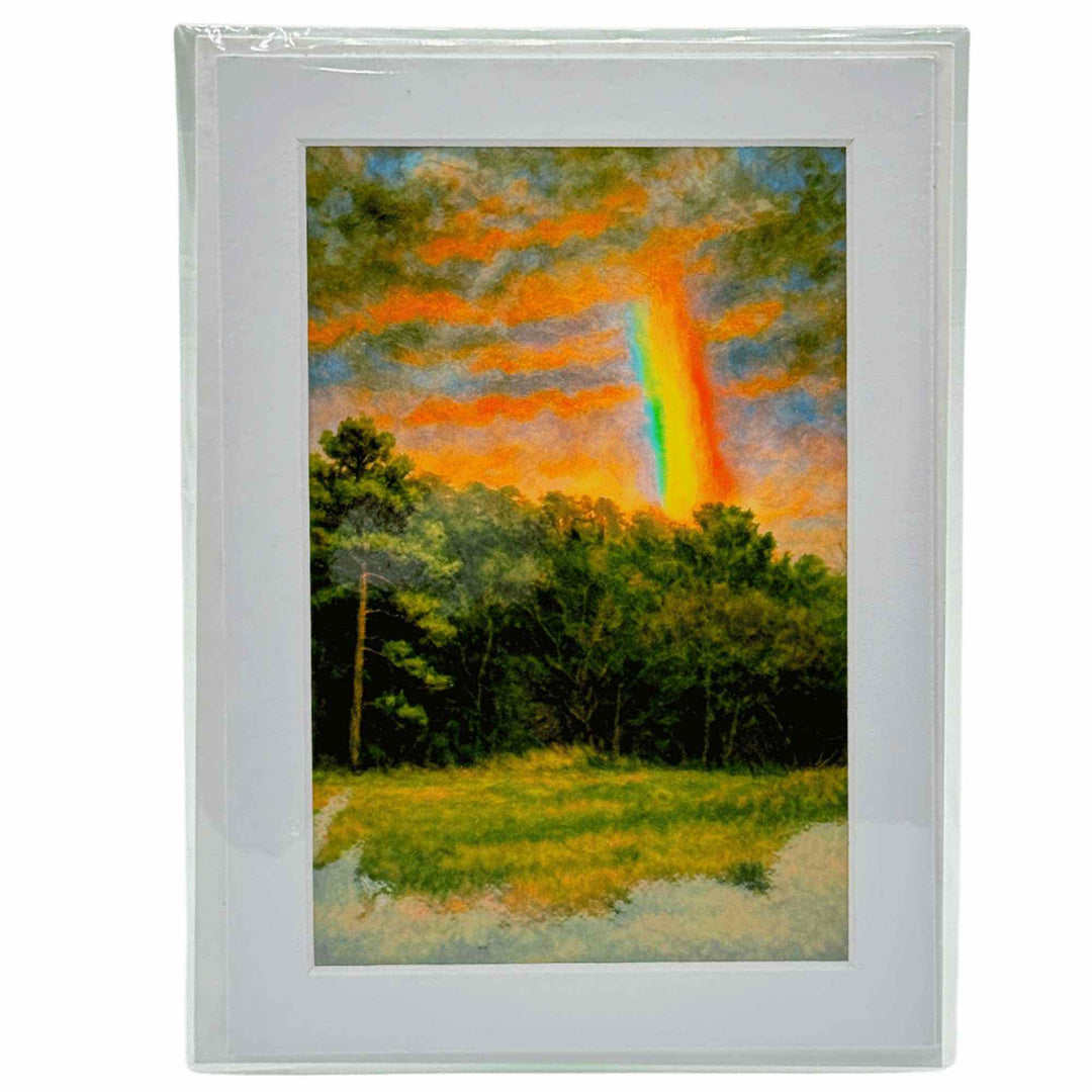 A greeting card with a A bright rainbow arching over trees and mist near a forested Ozark hillside.